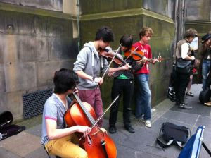 Young boys playing cello and fiddles on the street