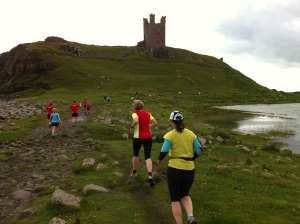 Runners approach Dunstanburgh castle