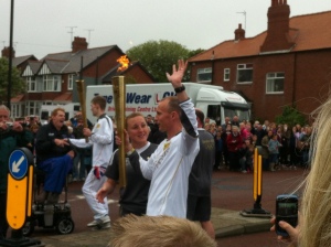 Michael Moore takes the Olympic flame from Jonny Miller